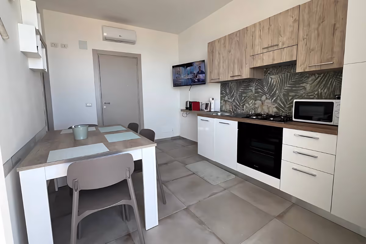 La zona giorno con cucina attrezzata e televisore